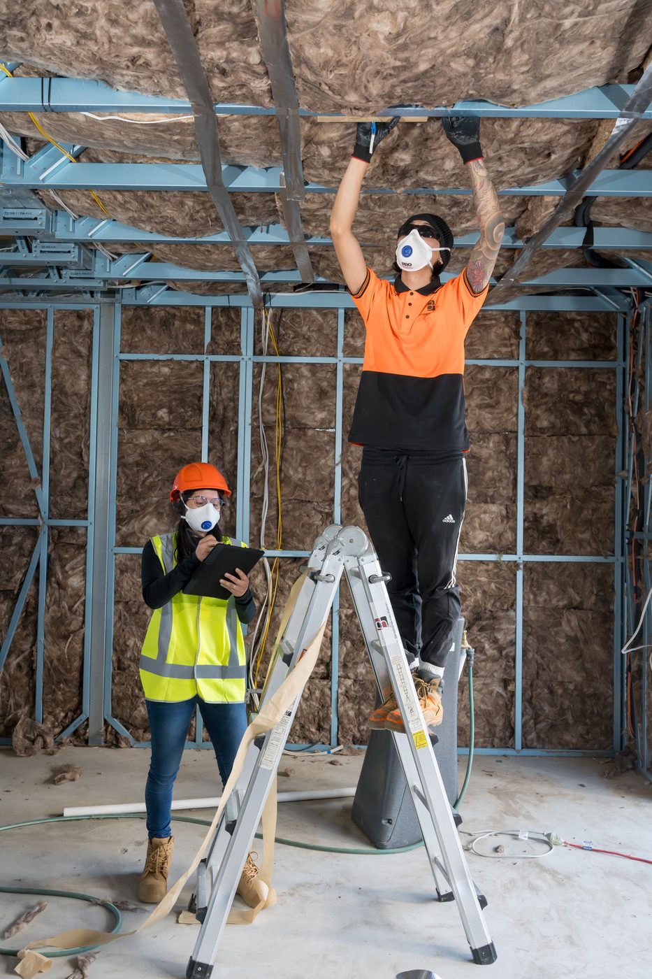 Insulation installer training — Energy Efficiency Skills Institute student installing bulk insulation in ceiling space
