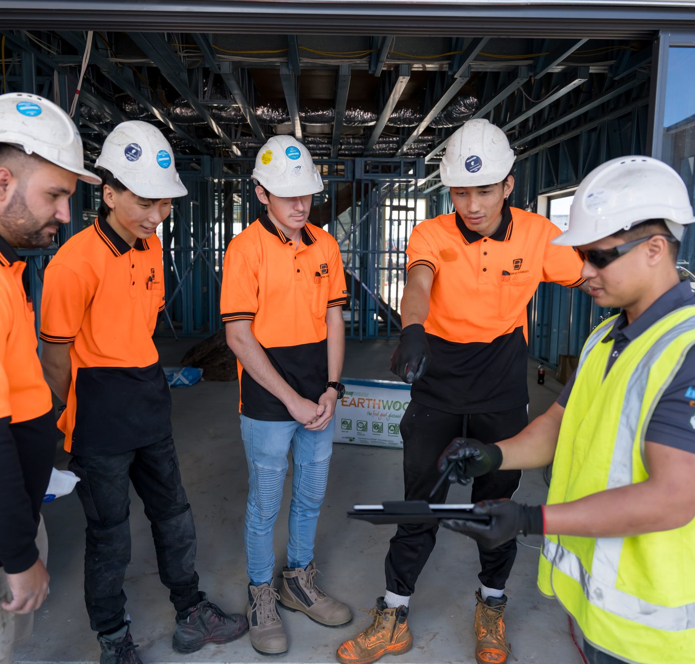 Insulation installer training group briefing — Energy Efficiency Skills Institute students on site